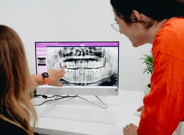 Una paziente guarda la radiografia sullo schermo insieme alla dentista